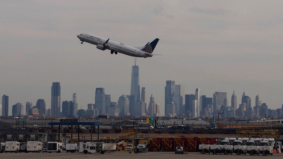 Plane taking off with Newark skyline in background