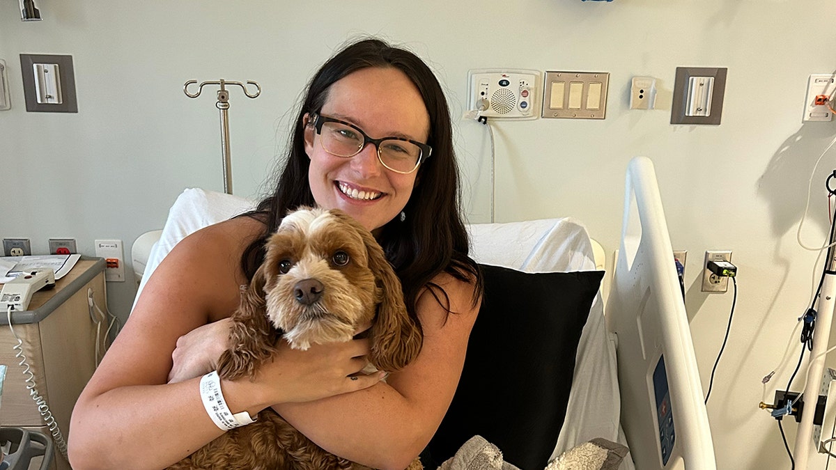 Breanna Bortner holds her cockapoo, Mochi, in the hospital.