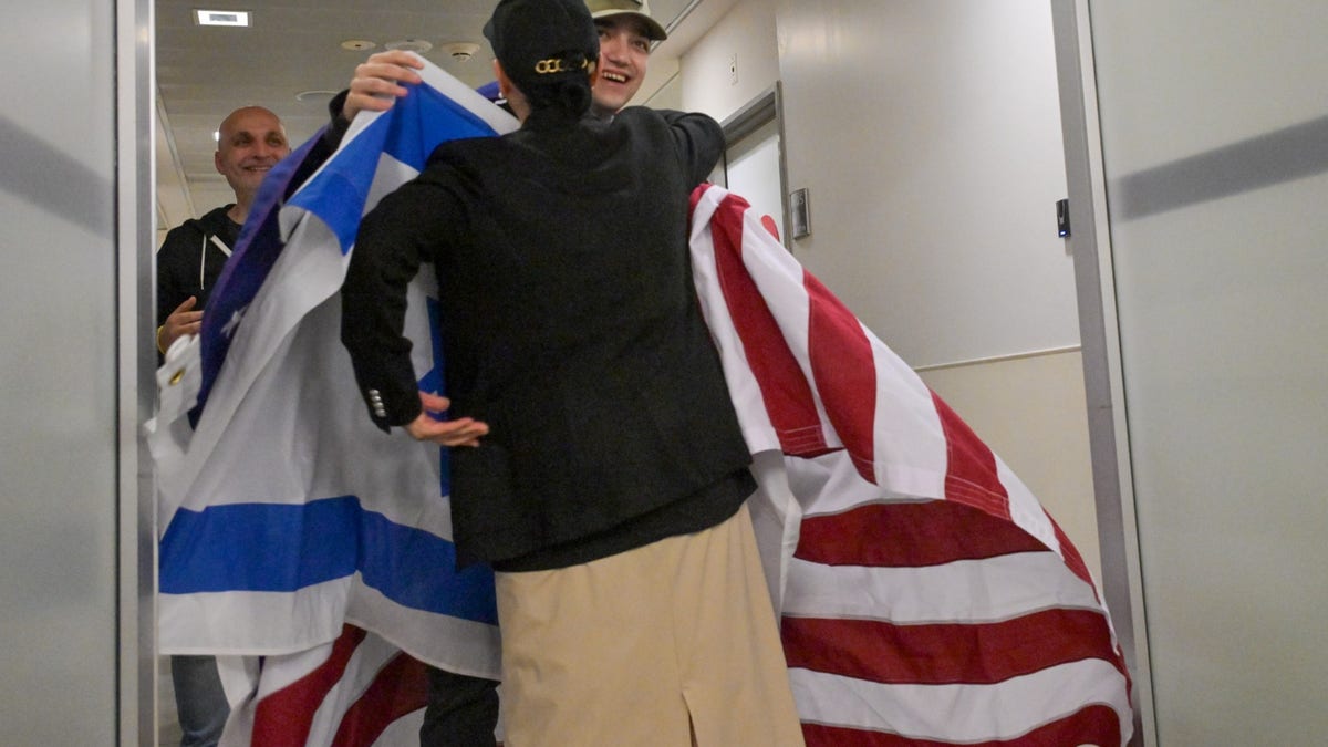 Edan Alexander greets family, holding Israel, US flags