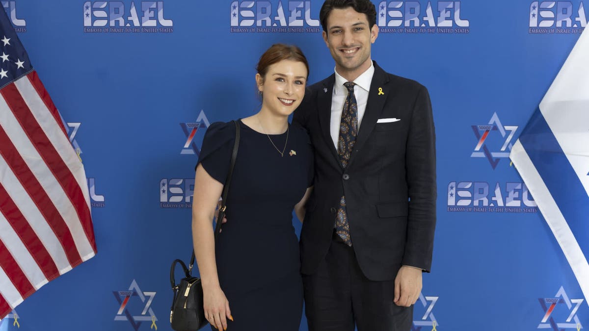Sarah Lynn Milgrim (Left) wearing a long navy dress and Yaron Lischinsky (Right) wearing a dark colored suit