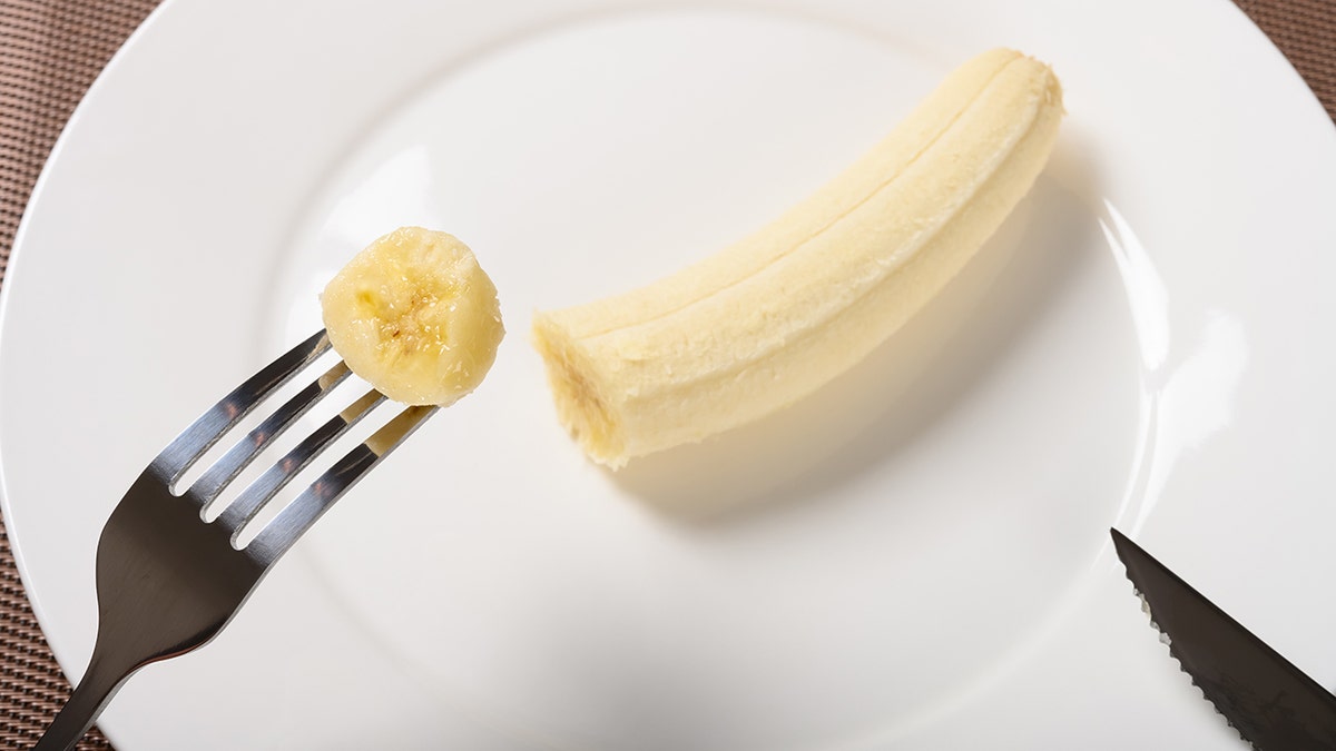 A fork and knife are used for eating a banana.